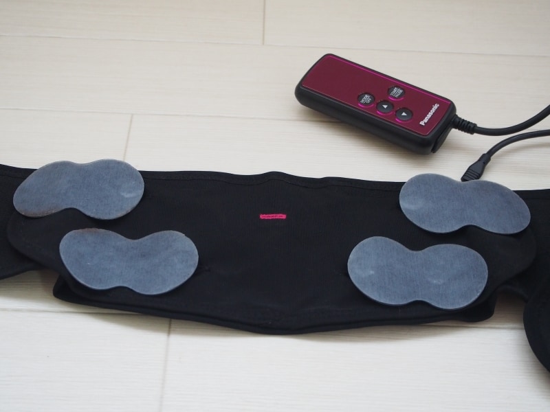 ベルトの内側に電極パッドを4枚セット。ピンクの目印がおへそに当たるように巻き付けます