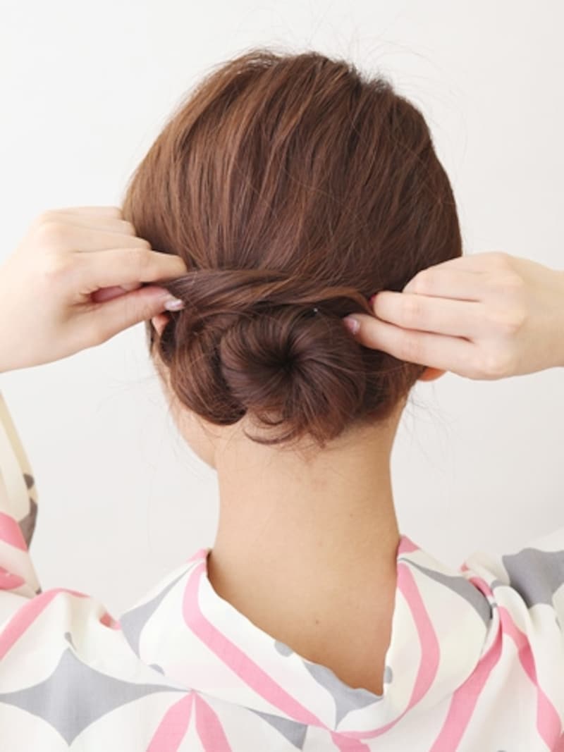 耳前の髪を外側にねじりながらシニヨンに巻きつける