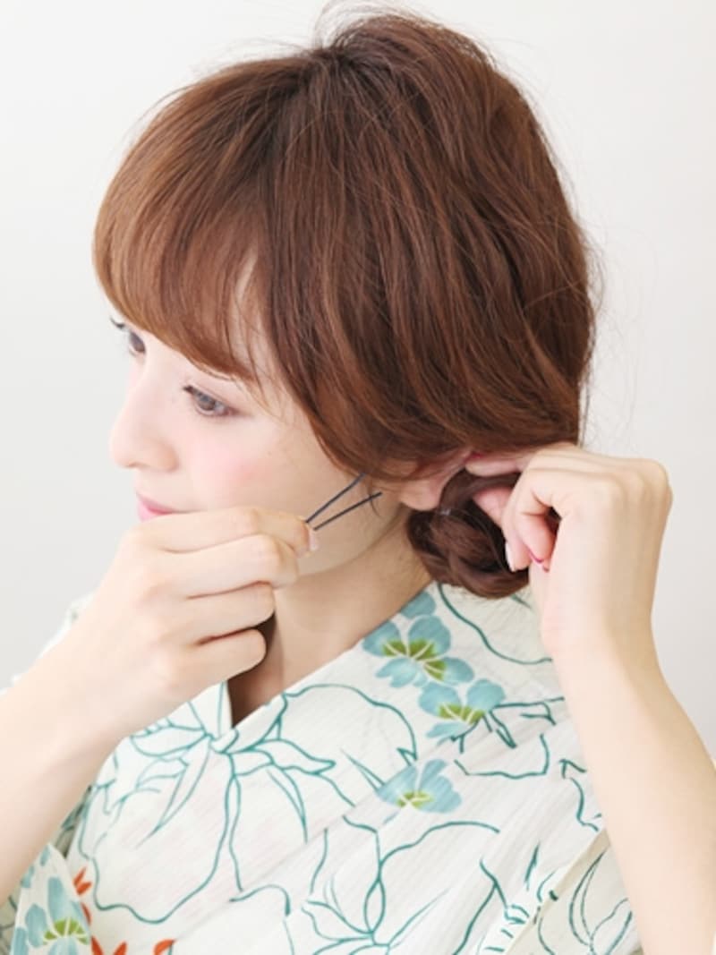 三つ編みを内側に折り曲げ、毛先を隠しながらピン留め