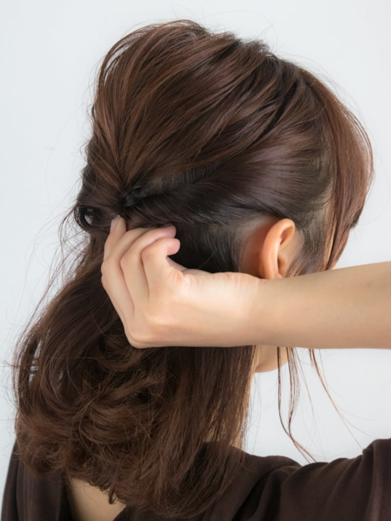 サイドの髪を後ろに向かってねじる
