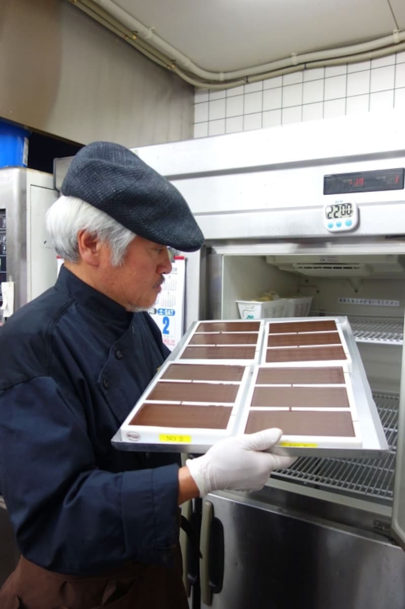 完成したばかりのチョコレートをチェックする三枝俊介シェフ