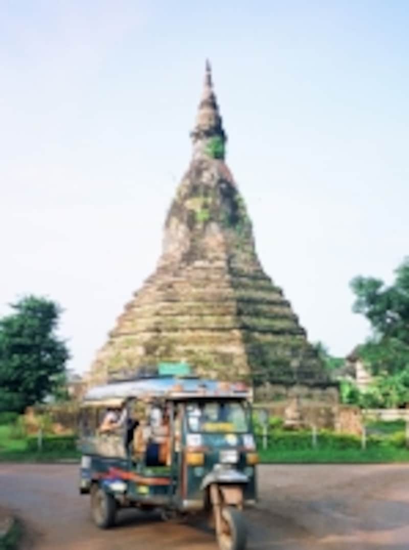 ビエンチャンのタート・ダム（黒塔）前を走り抜けるラオスのトゥクトゥク