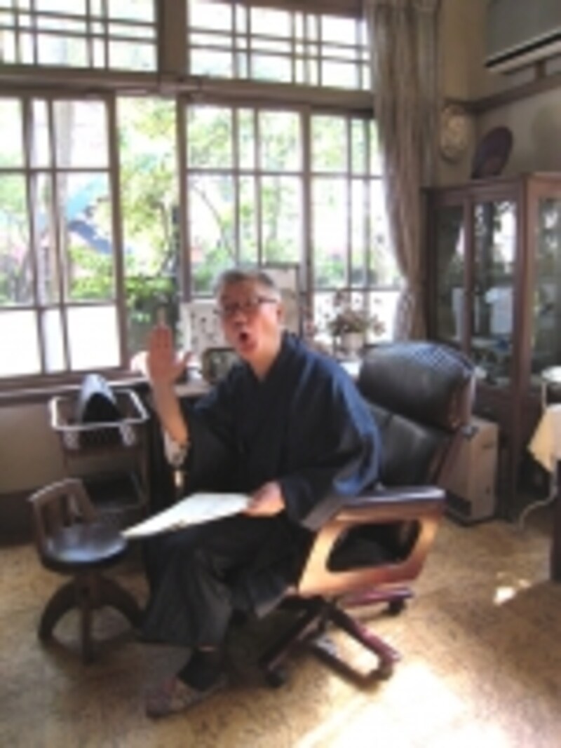 御成通りにある安保（あんぼう）歯科医院の診察室でポーズを取る下関マグロさん。建物の雰囲気とばっちり合っています！