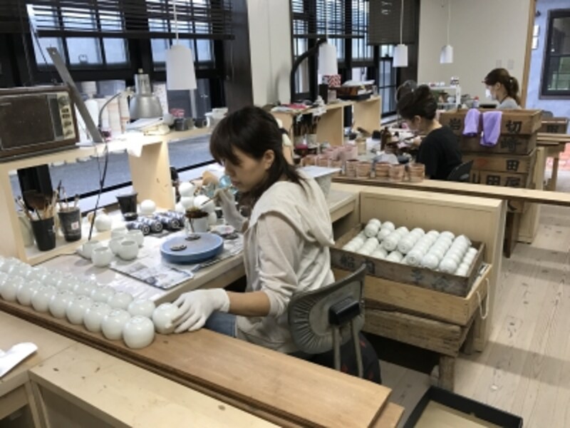 繊細な絵付けの作業。女性も多く働いている。