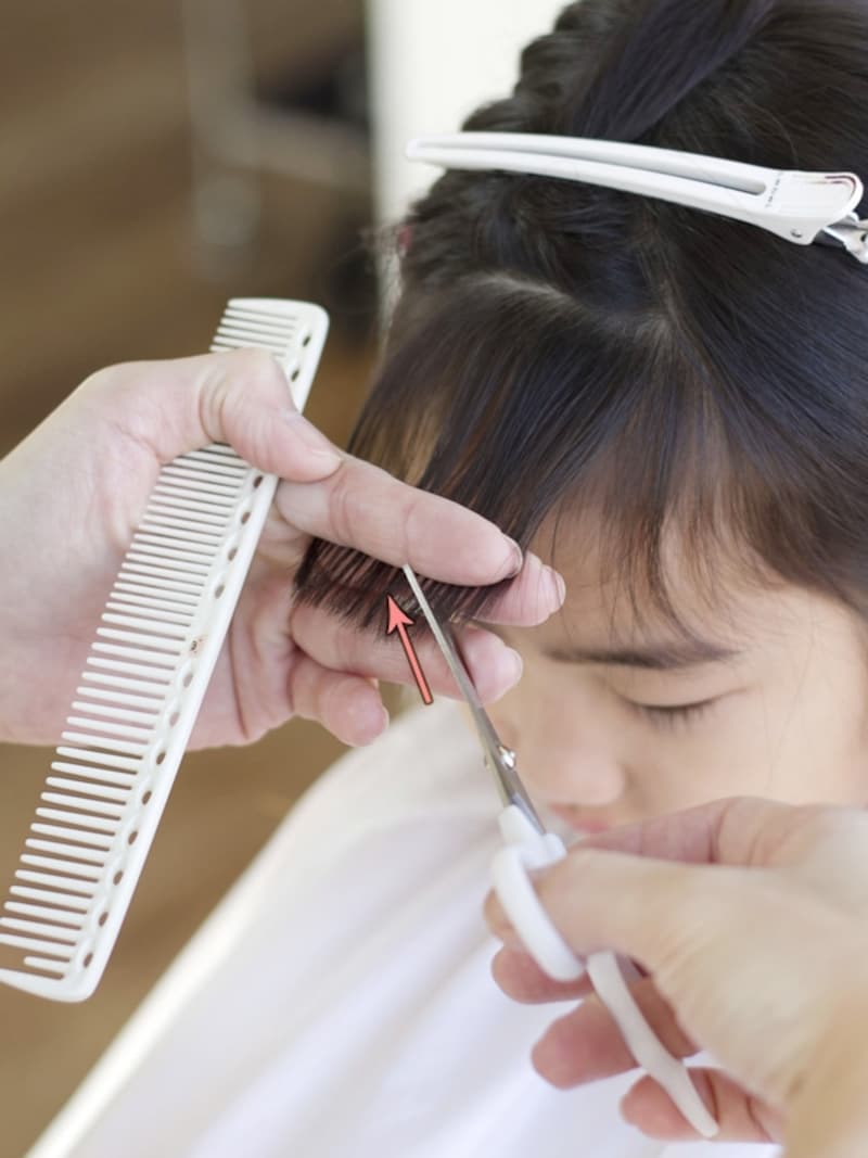 前髪に斜めに少しずつハサミを入れる