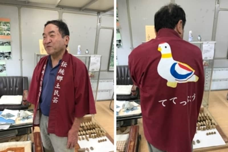 尾崎人形の作り手、高柳政廣さん。鳩笛の絵柄の法被を着てくれました。