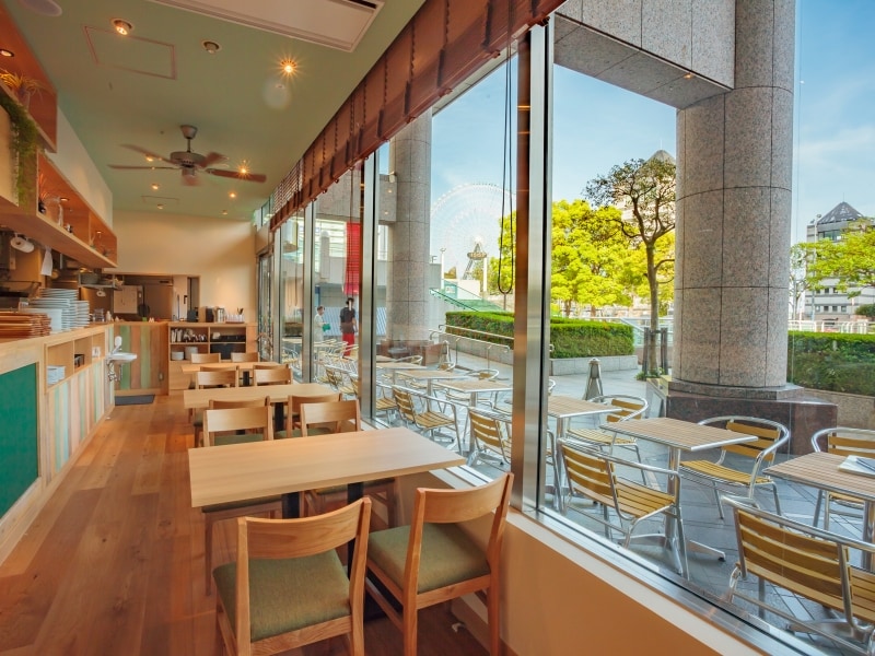 店内は古材を使ったアンティーク調のインテリアで、木の温もりが感じられるテーブルやチェアーが並びます。テラス席はペット連れOK(画像提供:湘南パンケーキ)