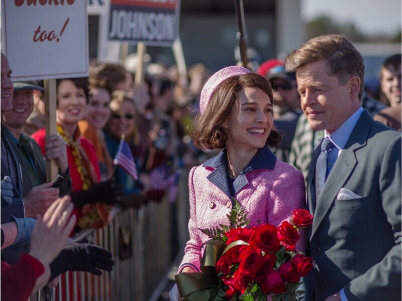 オープンカーのパレードに、ジャッキーはピンクのシャネルスーツとピルボックス帽を身につけて臨みました。(C)2016 Jackie Productions Limited