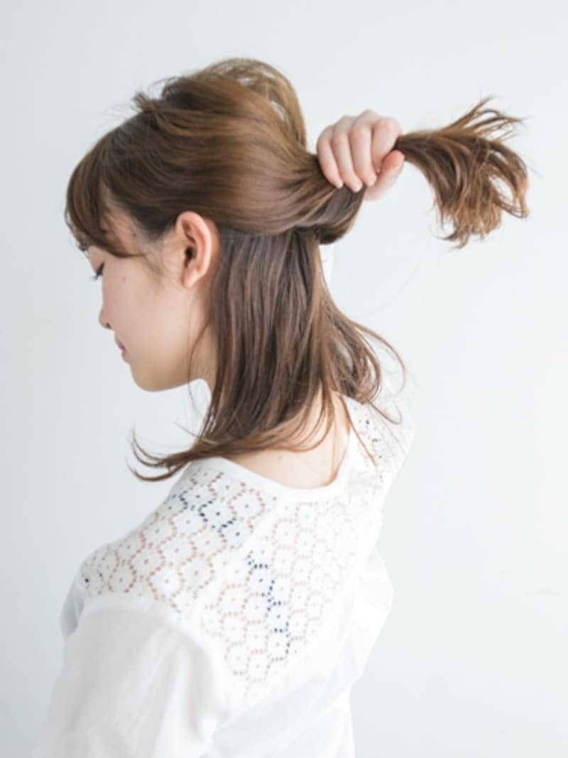 上の毛束をやや低めの位置でまとめる