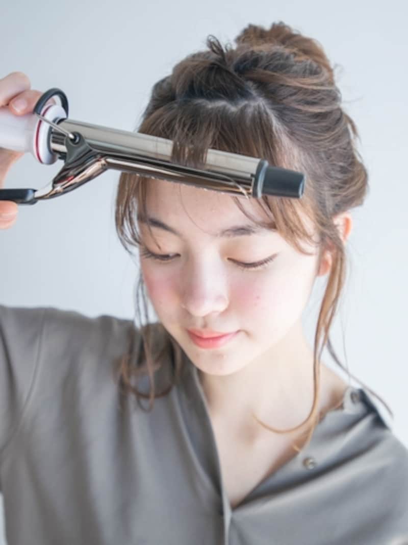 細めのアイロンで前髪を巻く