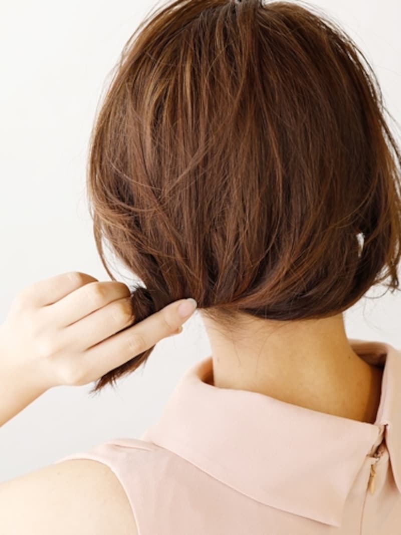 右サイドから左下へ、毛先を内側にねじり込む