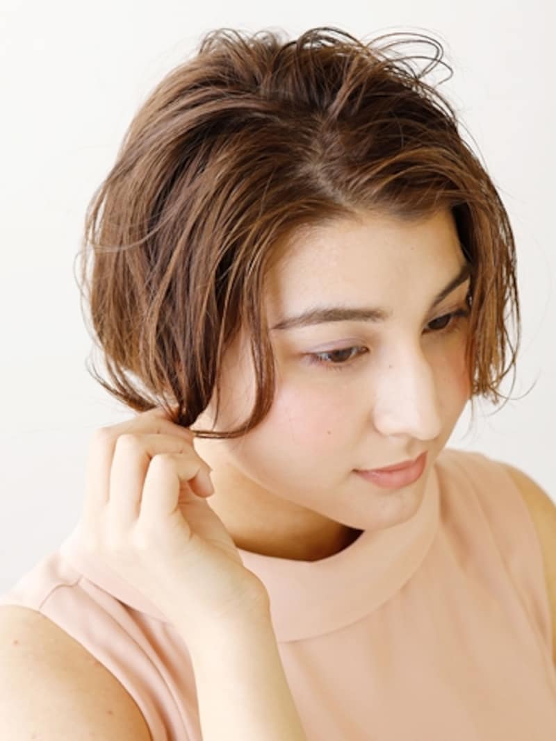 顔まわりの髪を巻き、ほぐしながら毛束を作る