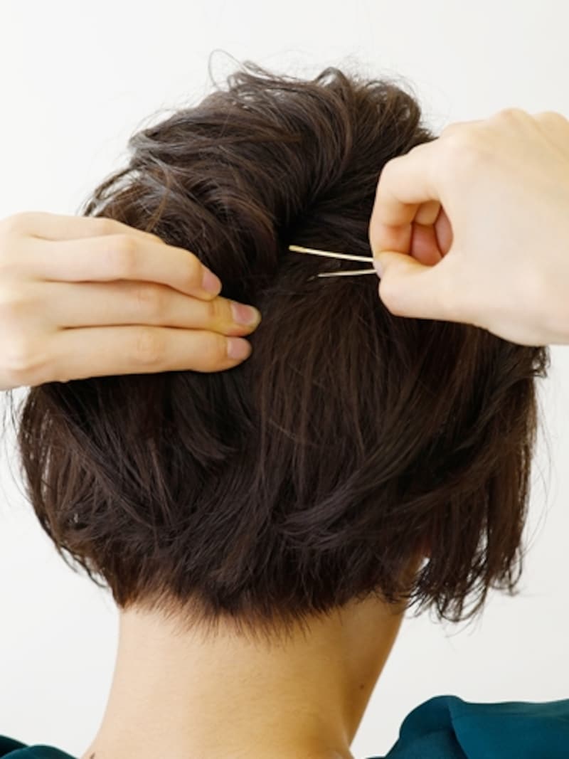 ねじった毛束を少し押し上げながらピンで固定