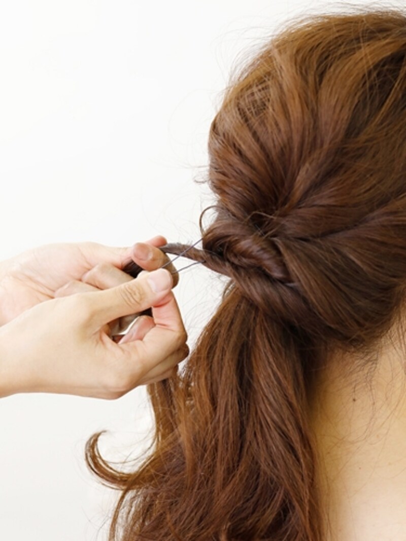 残りの髪を2つに分け、ねじりながらピンで固定