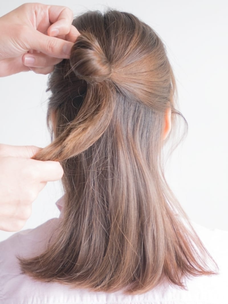 分けとった髪をゴムで結ぶ