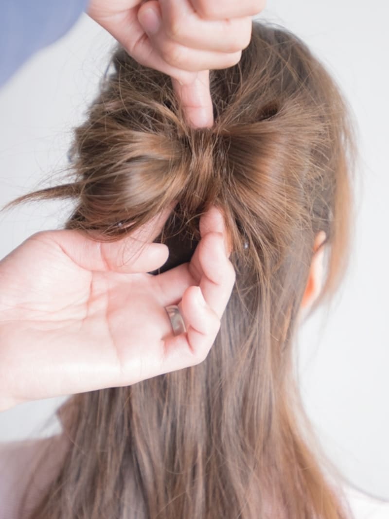 （A）の毛束を少しとり、結び目を隠す