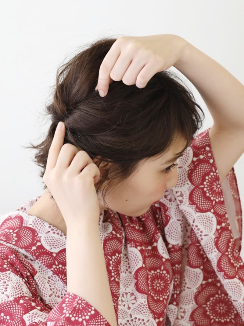 結び目を押さえながら、毛束を引き出す