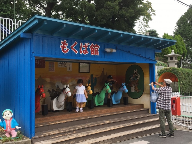 思い出のある木馬に孫を連れてくる市民