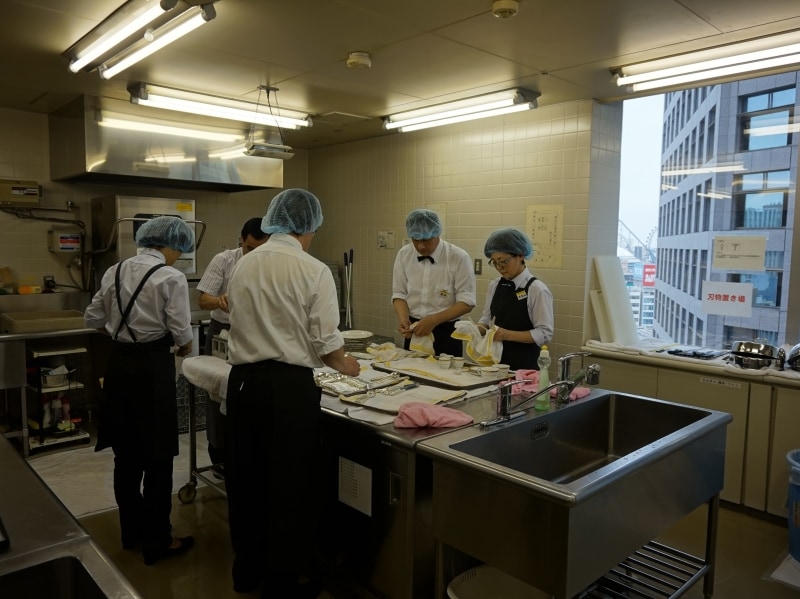 厨房では、調理器具や食器を洗う。講師の指導のもと効率よく作業が進む