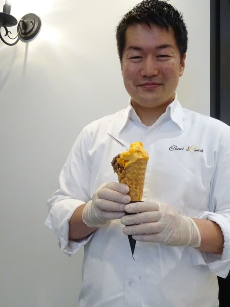 「シャンドワゾー グラシエ ショコラティエ」のオーナー村山太一シェフ。手にしているのは、コーン入りの「アプリコット」&「ショコラ」2種盛り