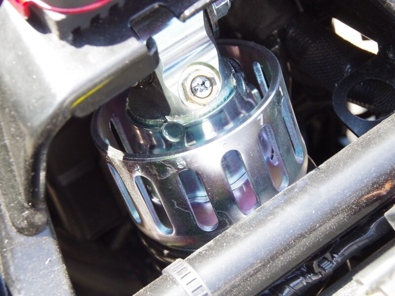 Vストローム250のシートを外すとサスペンションの頭が見える。この部分でプリロードの調整が可能です