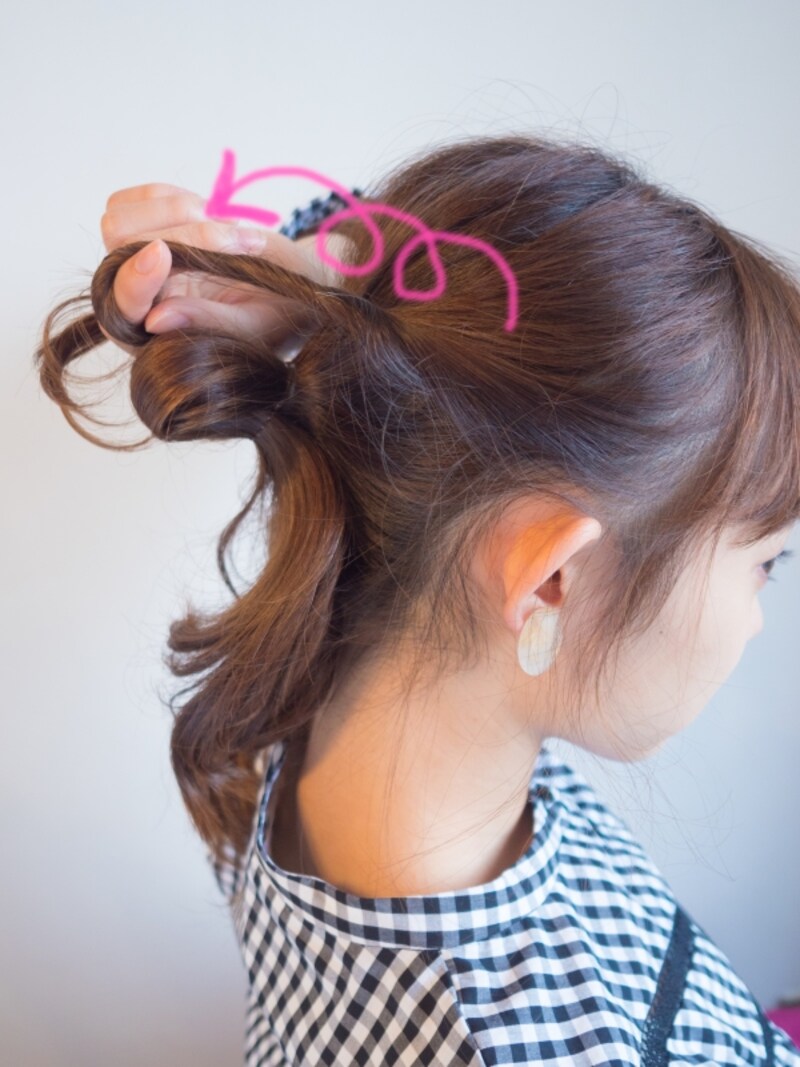 サイドの髪を後ろに引きながらねじる