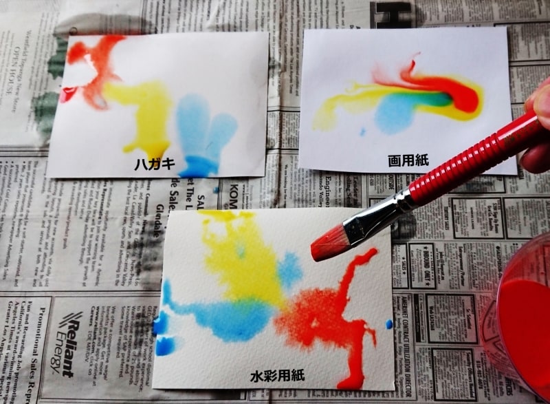 それぞれの紙に絵の具を落とす。にじみ方が違う。