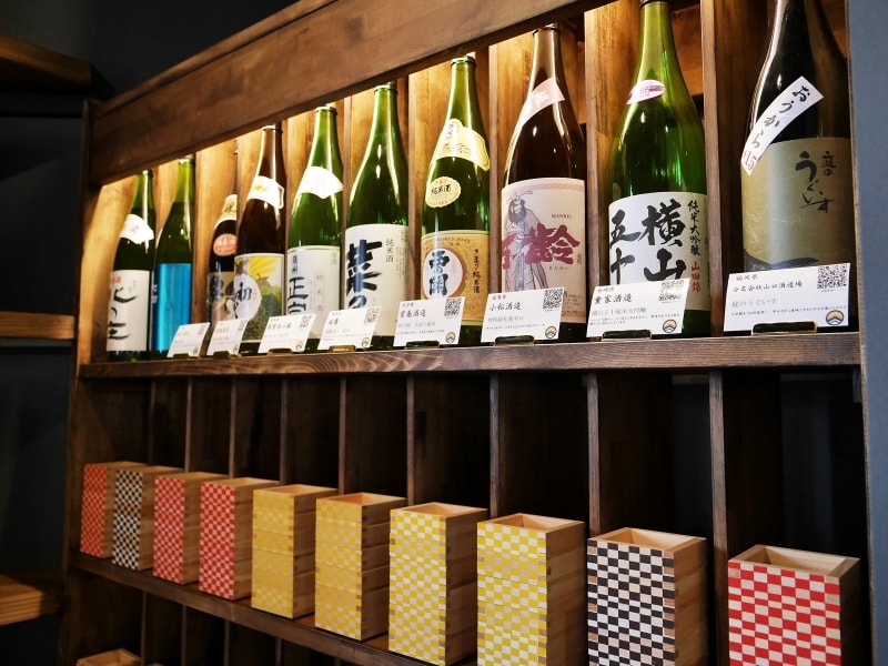 飲みたいお酒の下（もしくは上）の枡をカウンターに持っていくシステム。枡の色で料金がわかります。赤（290円）、黄（390円）、紫（490円）、青（590円）（2017年11月17日撮影）