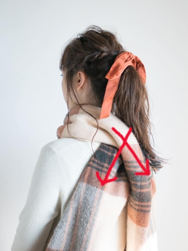 マフラーを背中でクロスさせる