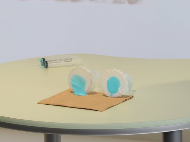 従来シート(左)と、「3D穴あきメッシュシート」に、ゆるゆるうんちを模した液体を垂らしてしばらくおき、傾けると……従来シートは液体が垂れてしまいました