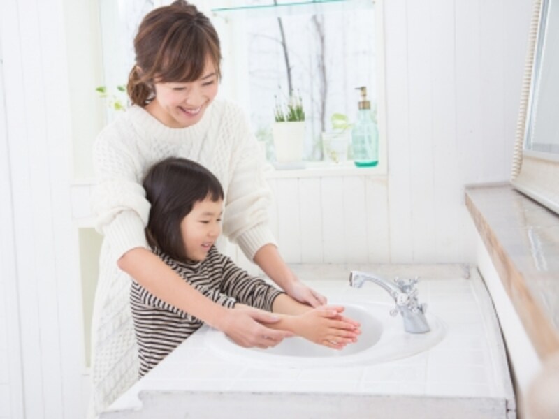 洗面所で手を洗う母と子ども