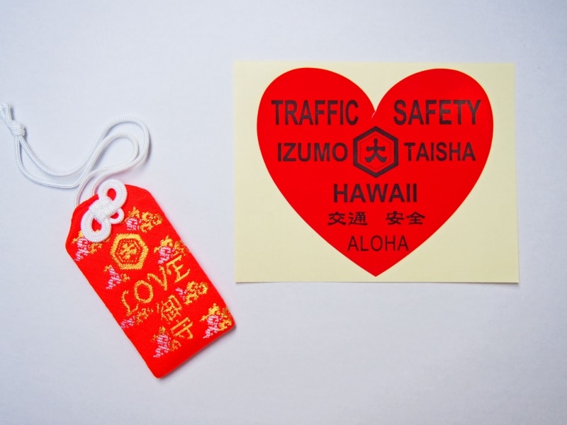 情熱的なLOVE御守と、ハート形の交通安全ステッカー。取材時にお受けしたお守りの初穂料は8ドル、ステッカーは3ドルでした