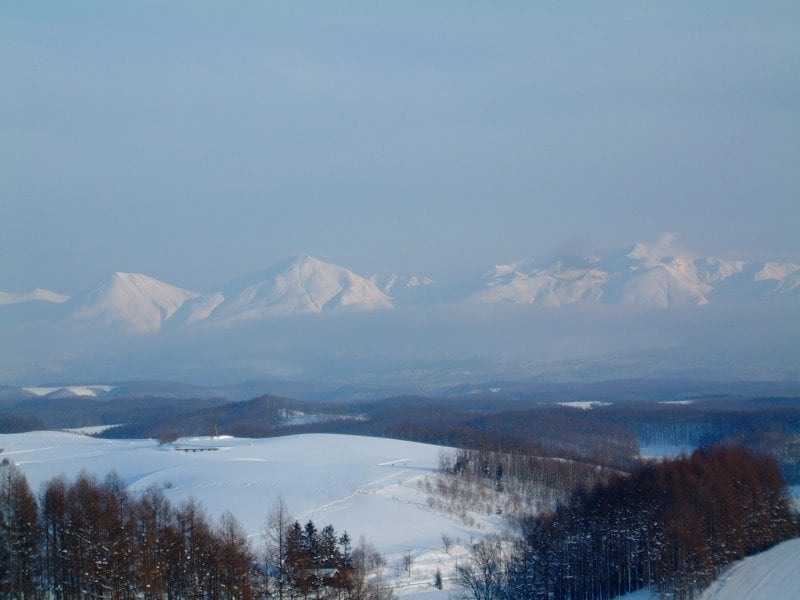 雪に覆われた丘と十勝岳連峰／四季彩の丘より