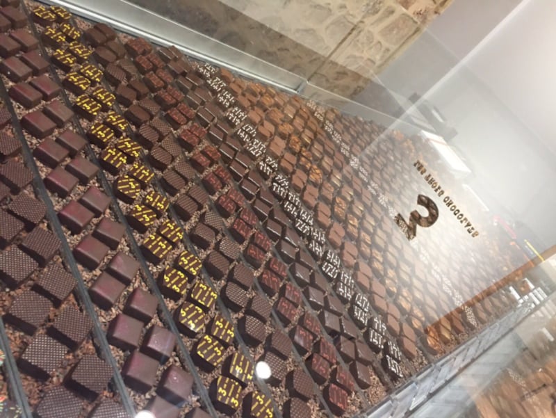 カカオニブが敷き詰められたショーケースに並ぶボンボンショコラ