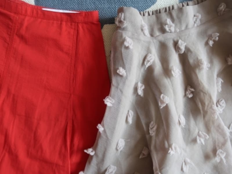 ジップアップ＆ボタンのもの（赤）と比べるとウエストゴムのスカート（ベージュ）は腰回りにボリュームが出がち