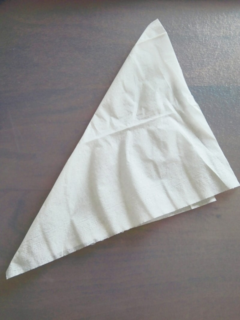 ティッシュを三角形になるように半分に折りたたみます