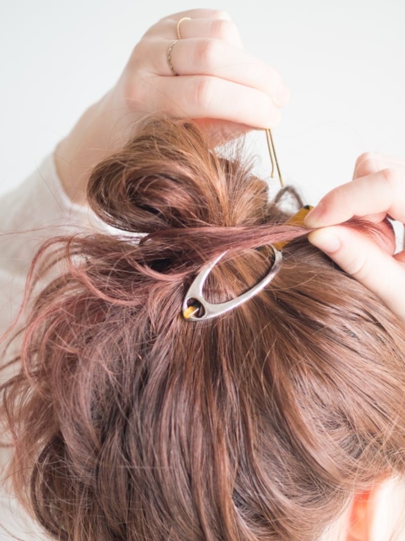 毛先をひと束つまんで隠す