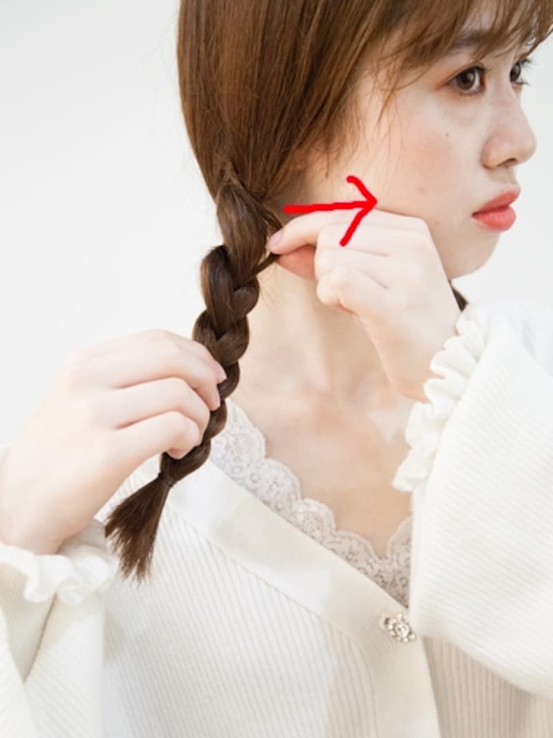 指先で三つ編みをつまみながら引き出す