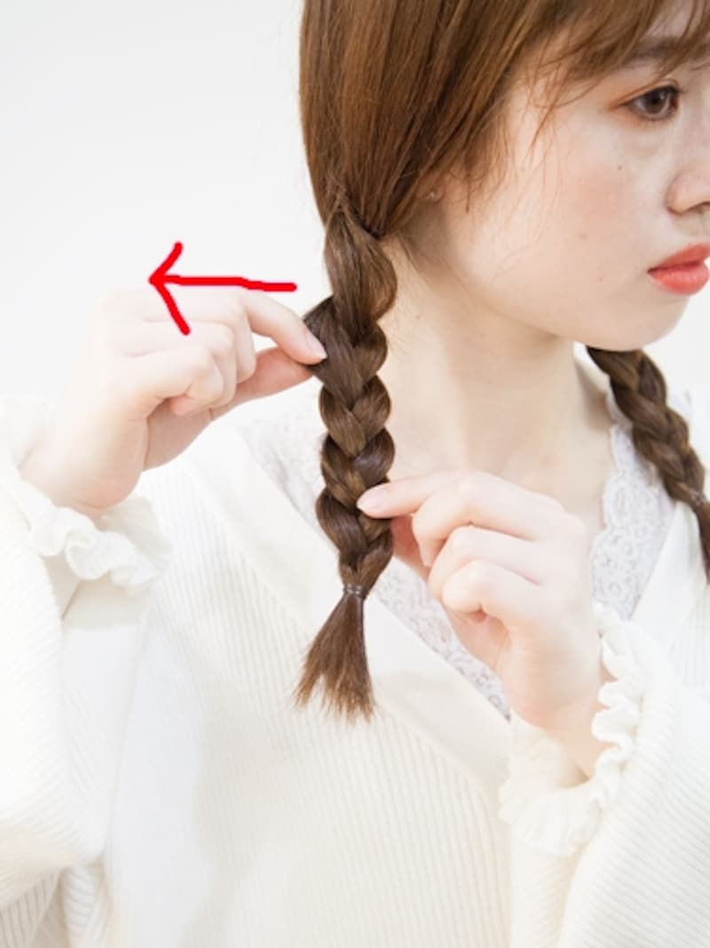 指先で三つ編みをつまみながら引き出す
