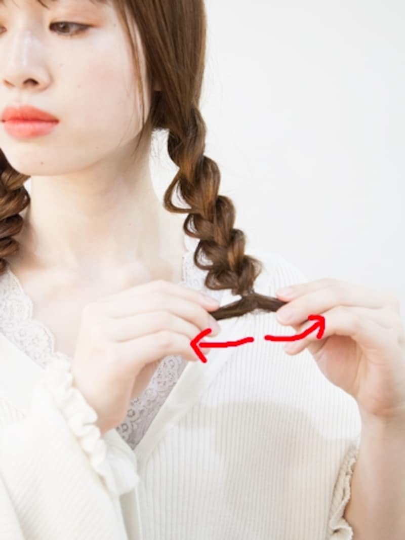 三つ編みおさげの毛先を左右に引っ張って締める