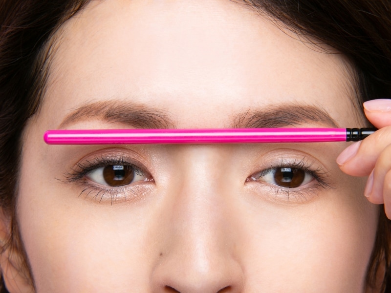 メイクブラシを眉頭に合わせて、バランスを見る