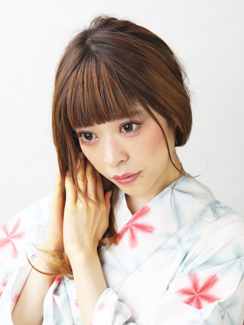 髪にヘアオイルをつけ、32ミリのコテで巻く