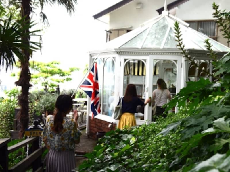 森の木々に包まれるようにたたずむ白いコンサバトリーは、隠れ家のよう