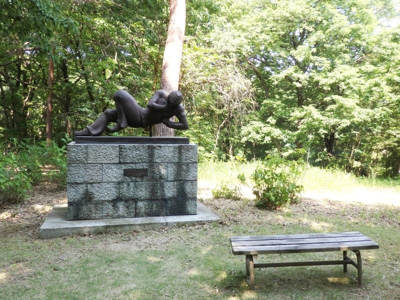 森の緑から浮かび上がる彫刻広場のアート作品