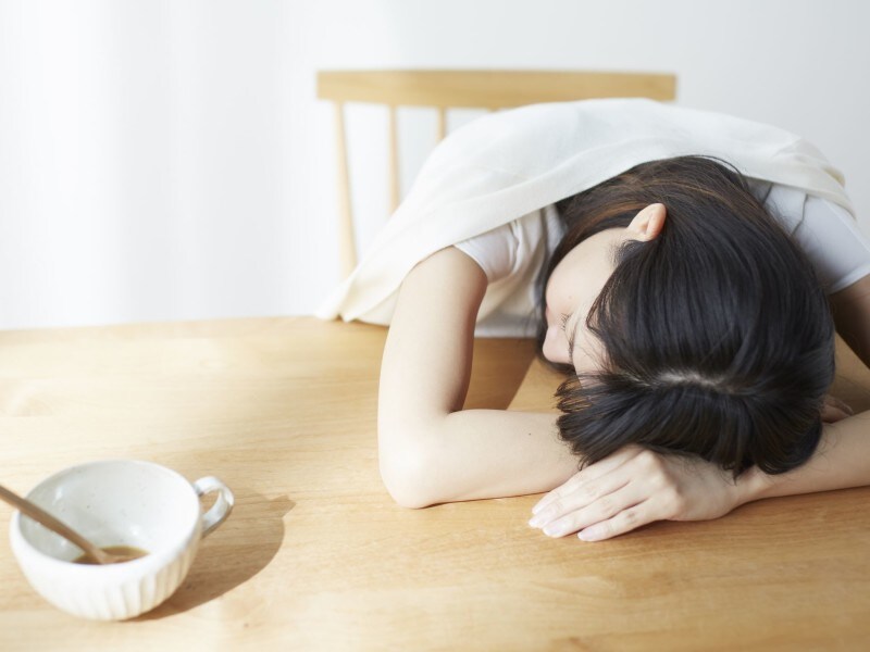 机に突っ伏して寝る女性