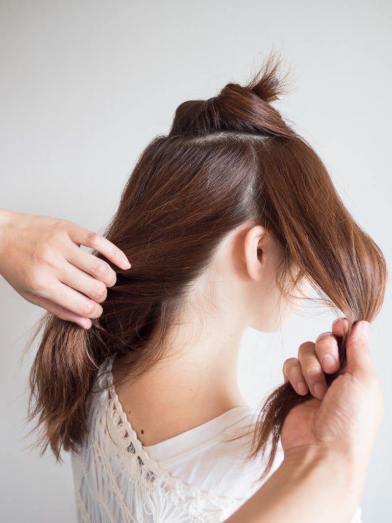 サイドの髪を手ぐしで分けとる