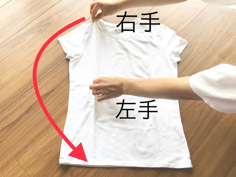 Tシャツのたたみ方の裏技・手順2:右手で肩のところをつまんだまま、矢印の先もつまむ