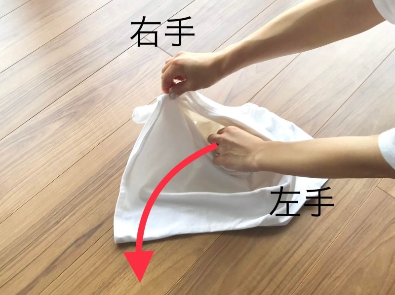 Tシャツのたたみ方の裏技・手順3:右手をしっかりつまんだまま、左手を抜き出す