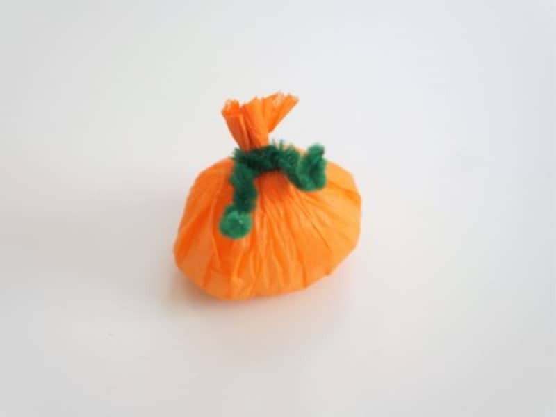 かぼちゃの上部に緑のモールを結び形を整えます。