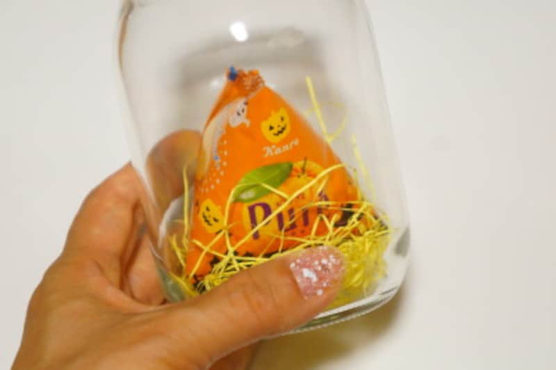 紙パッキンの上にお菓子を置きます。一番底に入れるお菓子はサイズの大きなものにしてください。